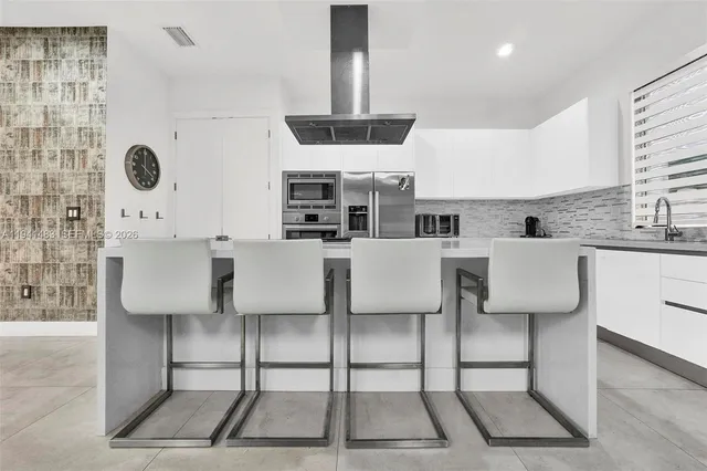 a kitchen with stainless steel appliances a stove a sink and white cabinets