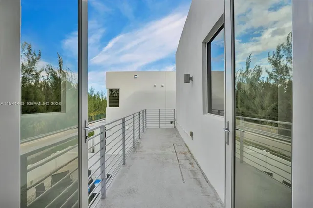 a view of a patio with couches chairs and floor to ceiling window