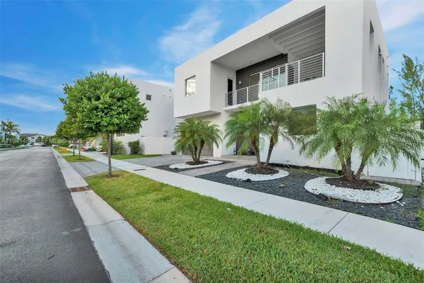 a view of a hallway with wooden floor and a dining room