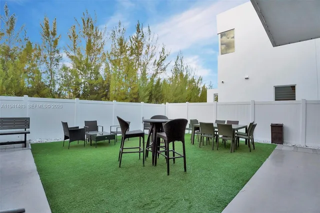 a view of a house with a small yard and potted plants