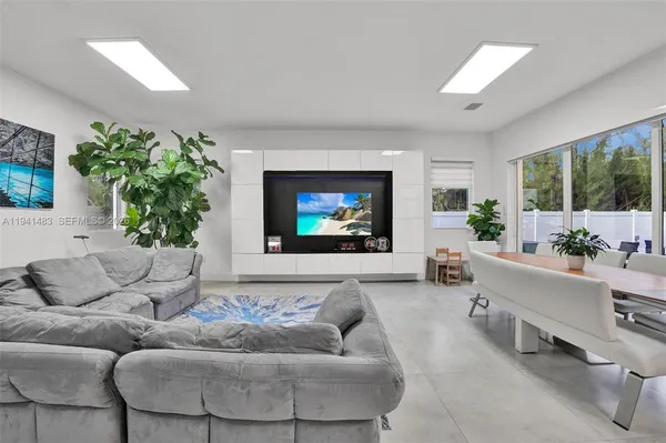 a living room with furniture kitchen view and a potted plant