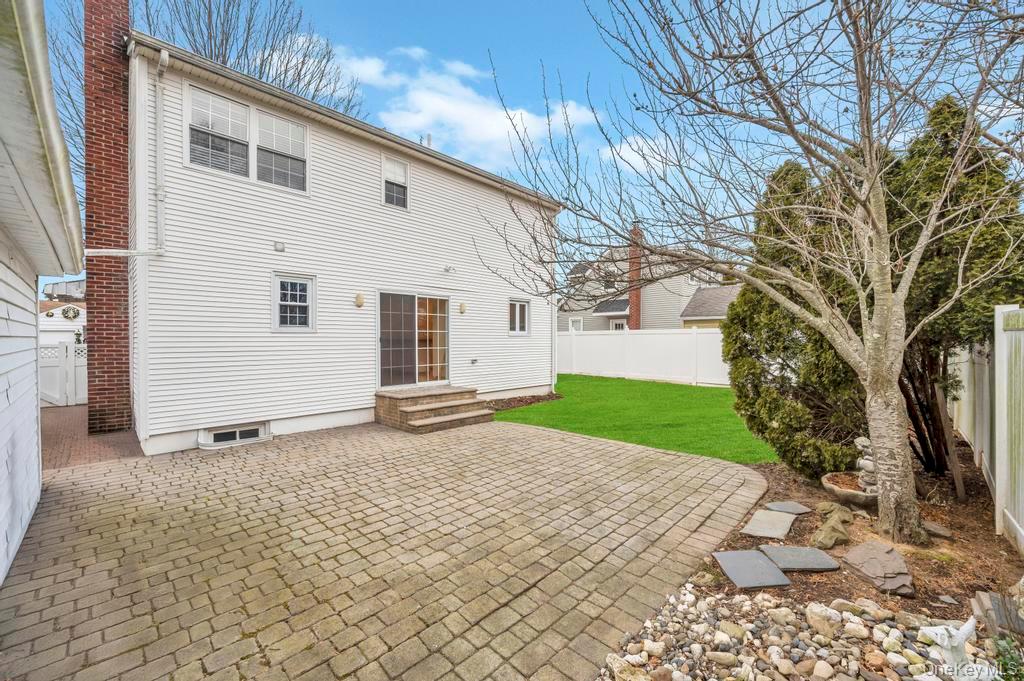 2585 Oceanside Road Oceanside, NY 11572 - Photo 24 of 30 a view of a white house with a yard and garage
