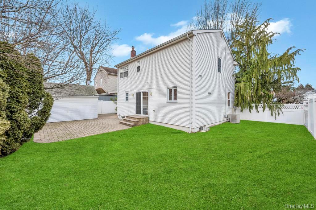 2585 Oceanside Road Oceanside, NY 11572 - Photo 25 of 30 a front view of a house with a garden and plants