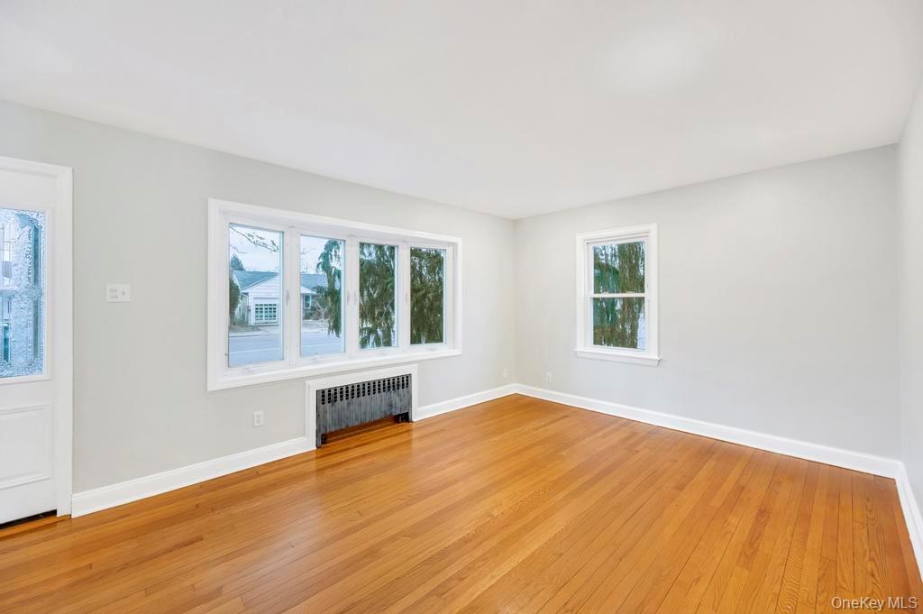 2585 Oceanside Road Oceanside, NY 11572 - Photo 3 of 30 a view of an empty room with wooden floor and a window