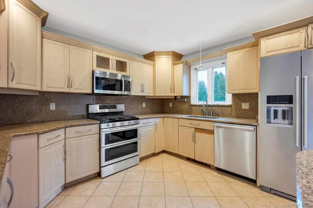 2585 Oceanside Road Oceanside, NY 11572 - Photo 7 of 30 a kitchen with stainless steel appliances granite countertop a stove a sink and a microwave