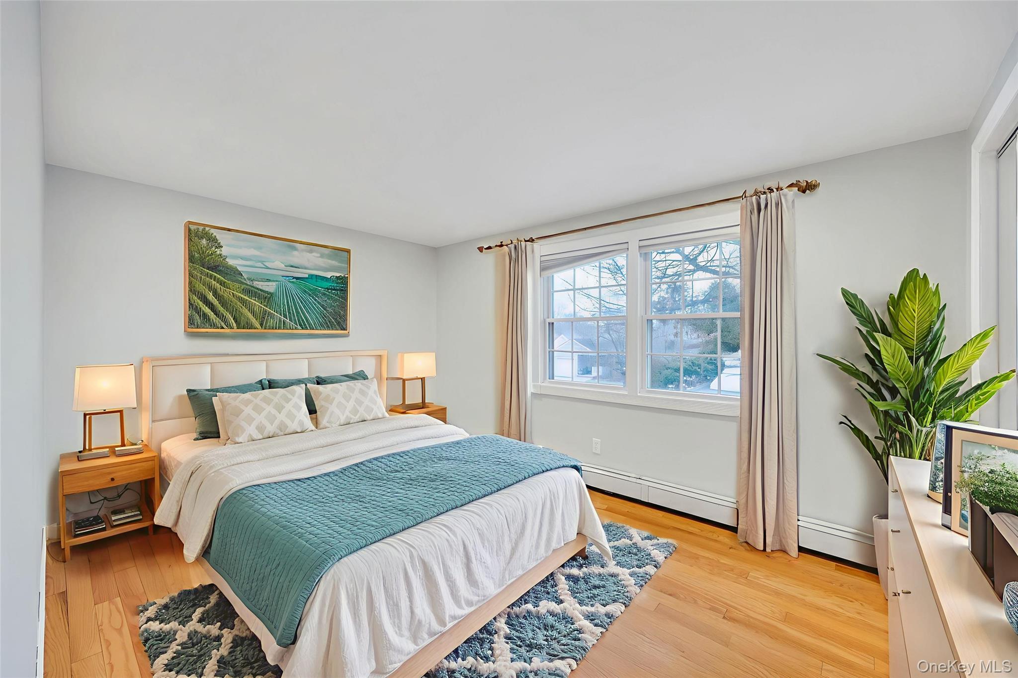 2585 Oceanside Road Oceanside, NY 11572 - Photo 8 of 30 a bedroom with a large bed and a potted plant