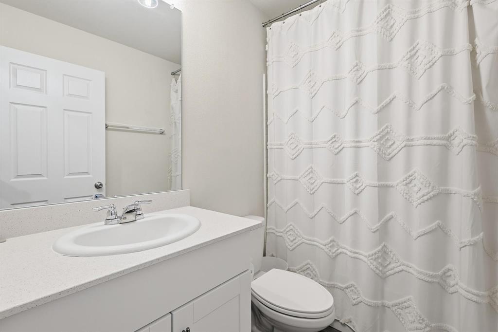 16041 Pious Drive Haslet, TX 76052 - Photo 13 of 36 Bathroom featuring a shower with shower curtain and vanity