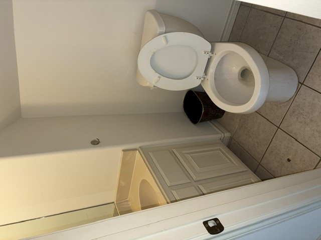 404 West 24th Street Bryan, TX 77803 - Photo 12 of 22 a white toilet sitting next to a sink and vanity