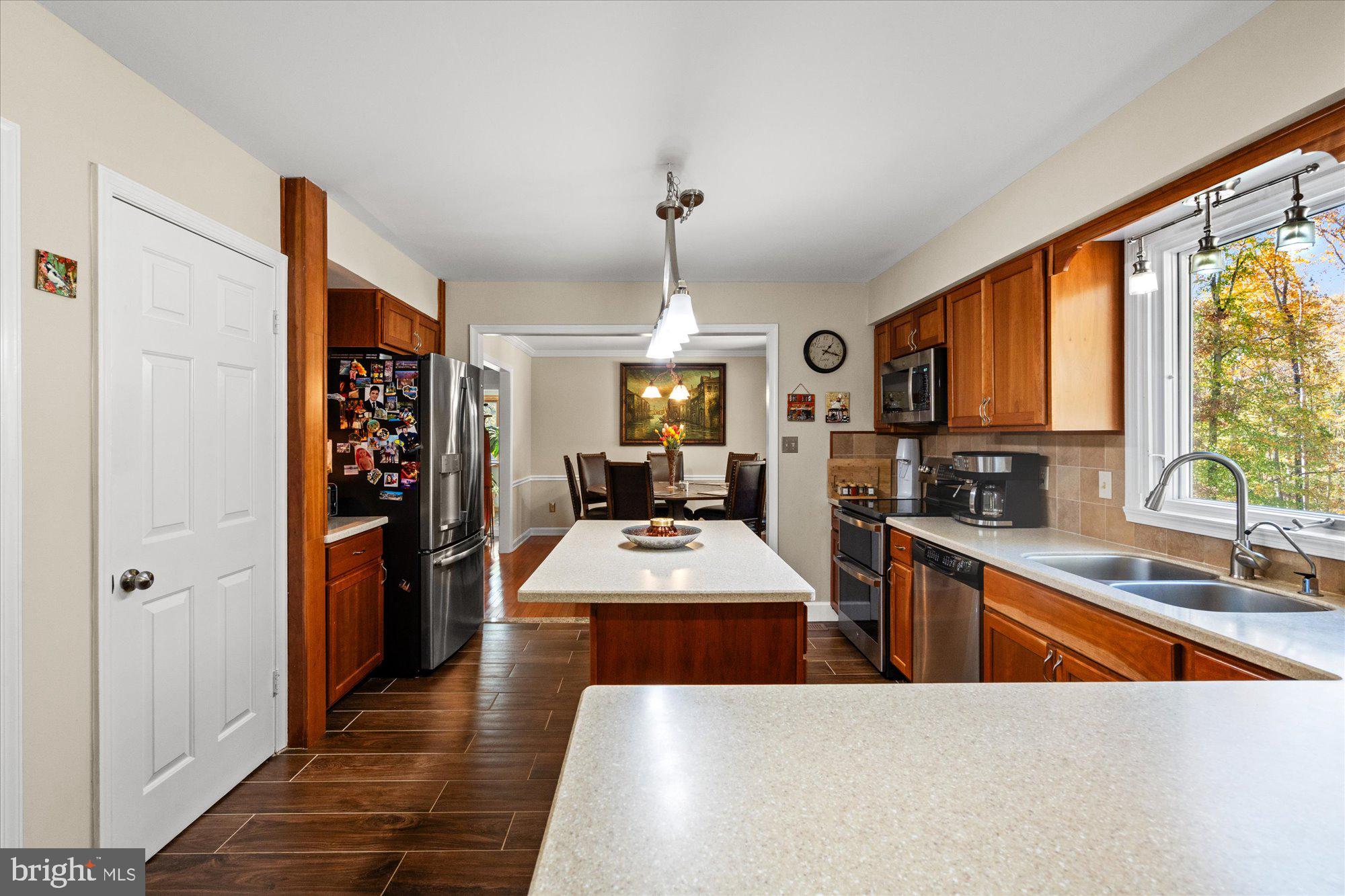 14520 Idlebrook Court Manassas, VA 20112 - Photo 61 of 87 a large kitchen with stainless steel appliances granite countertop a stove a refrigerator a sink dishwasher with wooden cabinets and dining table