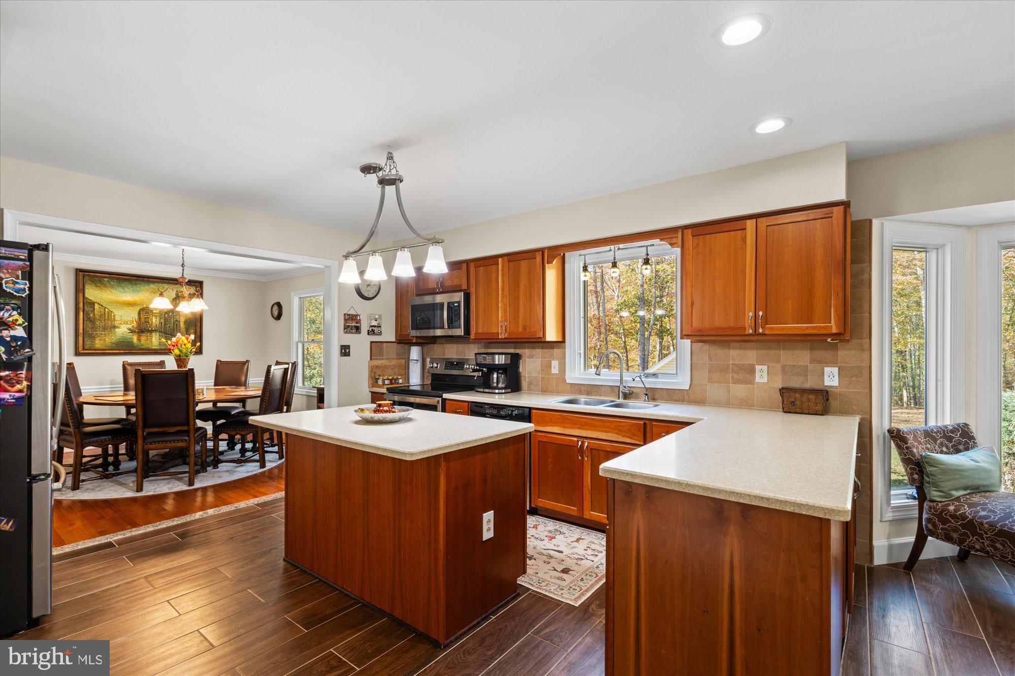 14520 Idlebrook Court Manassas, VA 20112 - Photo 66 of 87 a kitchen with a stove a sink a refrigerator wooden floor and a dining table