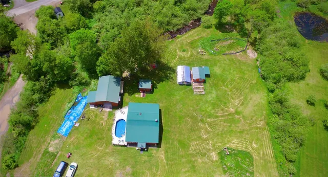 a view of an house with backyard and swimming pool