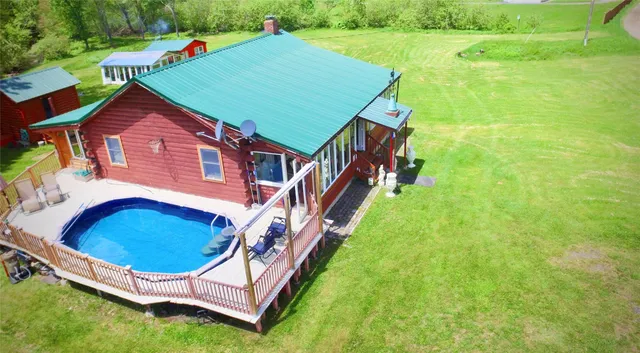 an aerial view of residential houses with outdoor space and trees