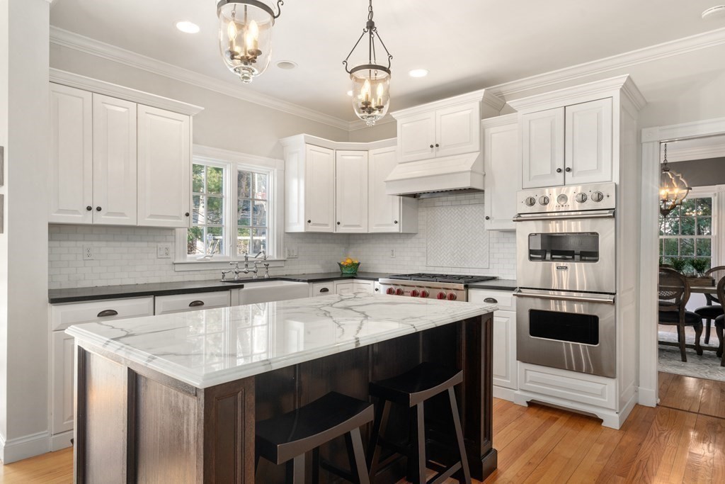 77 Monadnock Road Wellesley, MA 02481 - Photo 5 of 39 a kitchen with stainless steel appliances granite countertop a stove a sink dishwasher a refrigerator white cabinets and wooden floor
