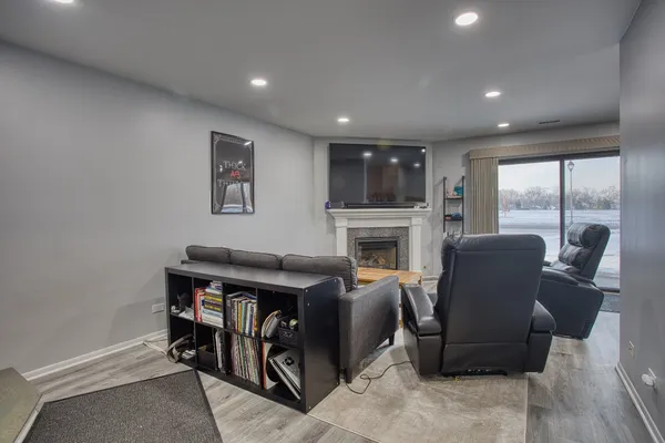 a living room with furniture a fireplace and a floor to ceiling window