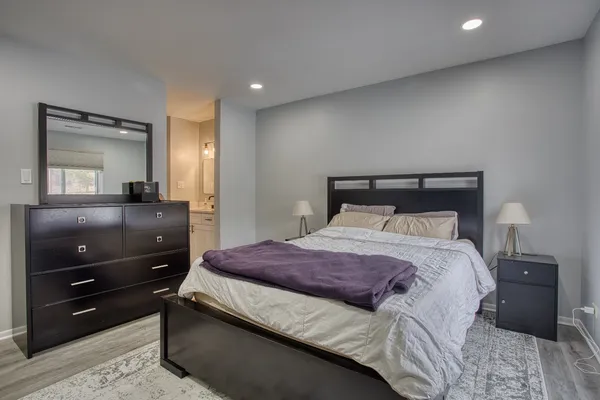 a bedroom with a bed and a mirror on dresser