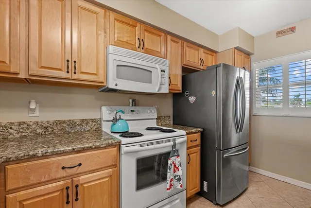 a kitchen with granite countertop cabinets and window