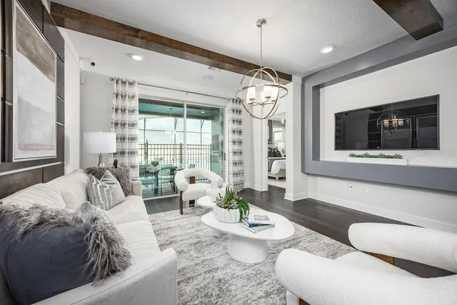 a living room with furniture chandelier and a flat screen tv