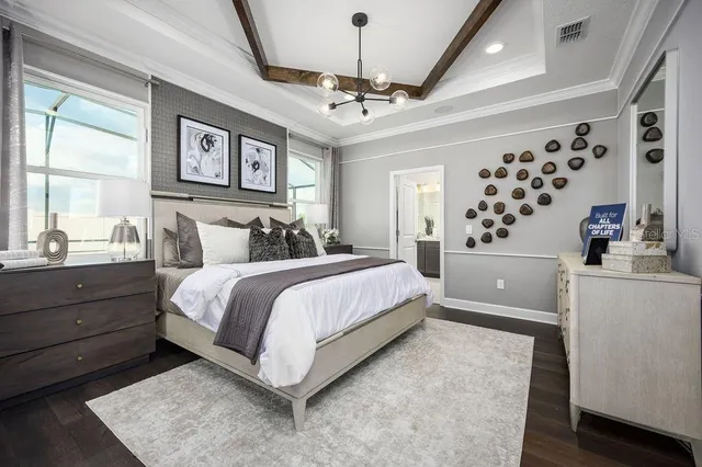 a bedroom with a large bed and a chandelier