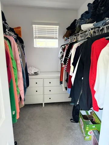 a view of walk in closet with clothes and shoes