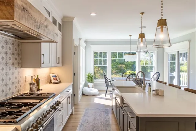 a kitchen with stainless steel appliances a sink a stove and a wooden floors