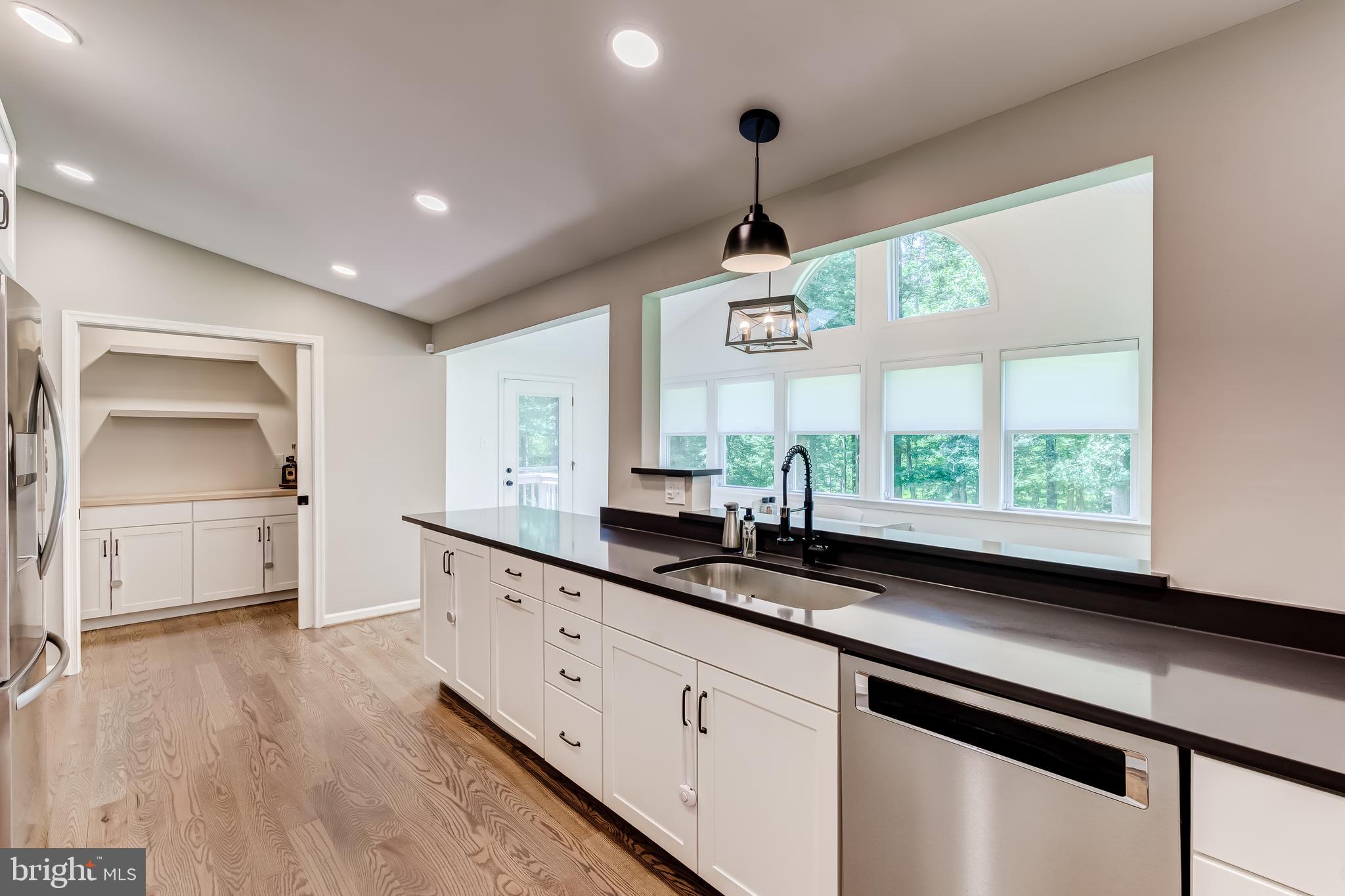 11926 Appling Valley Road Fairfax, VA 22030 - Photo 19 of 60 a kitchen with stainless steel appliances granite countertop a sink a window and wooden floor