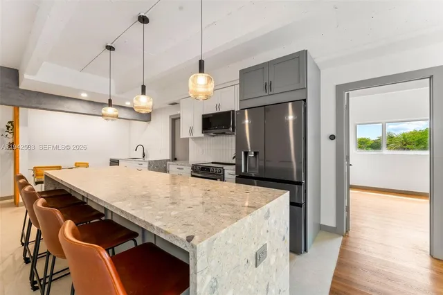 a kitchen with stainless steel appliances granite countertop a sink a refrigerator and a stove