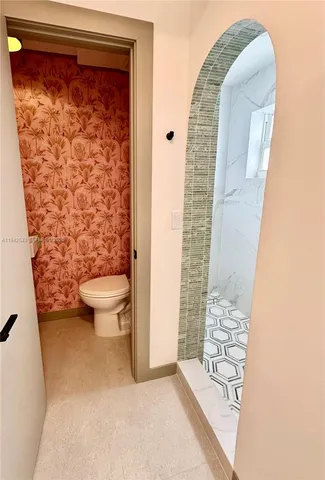 a bathroom with a toilet and a shower curtain