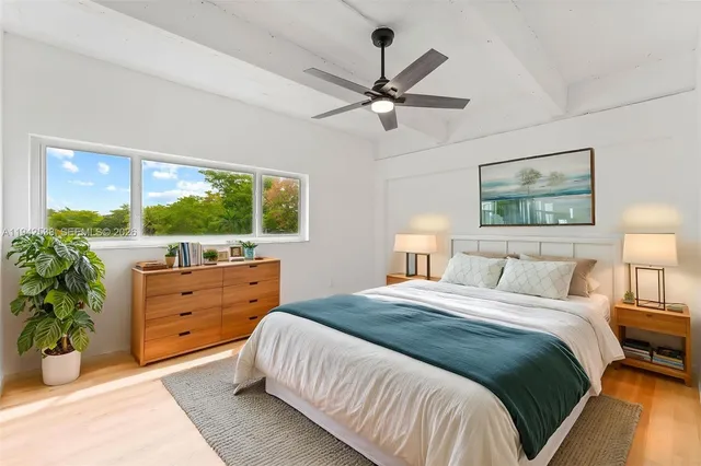 a bedroom with a bed and a large window