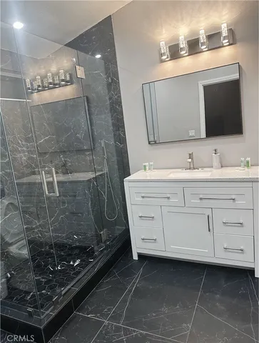 a bathroom with a granite countertop sink mirror and toilet