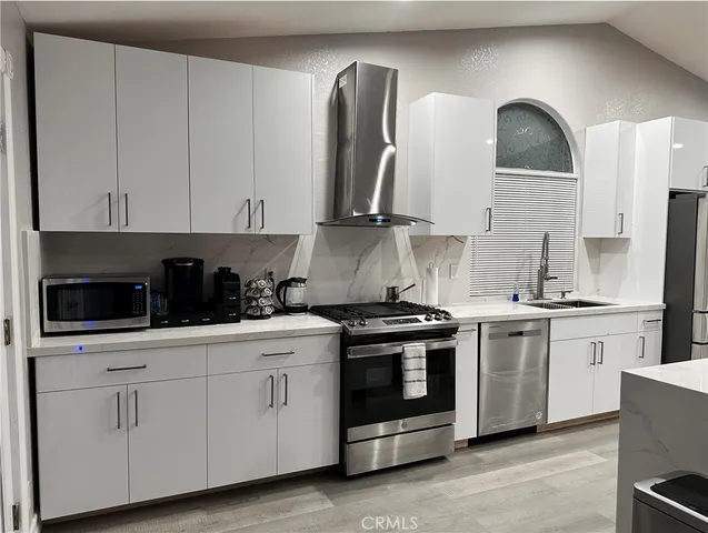 a kitchen with stainless steel appliances granite countertop white cabinets a sink and dishwasher