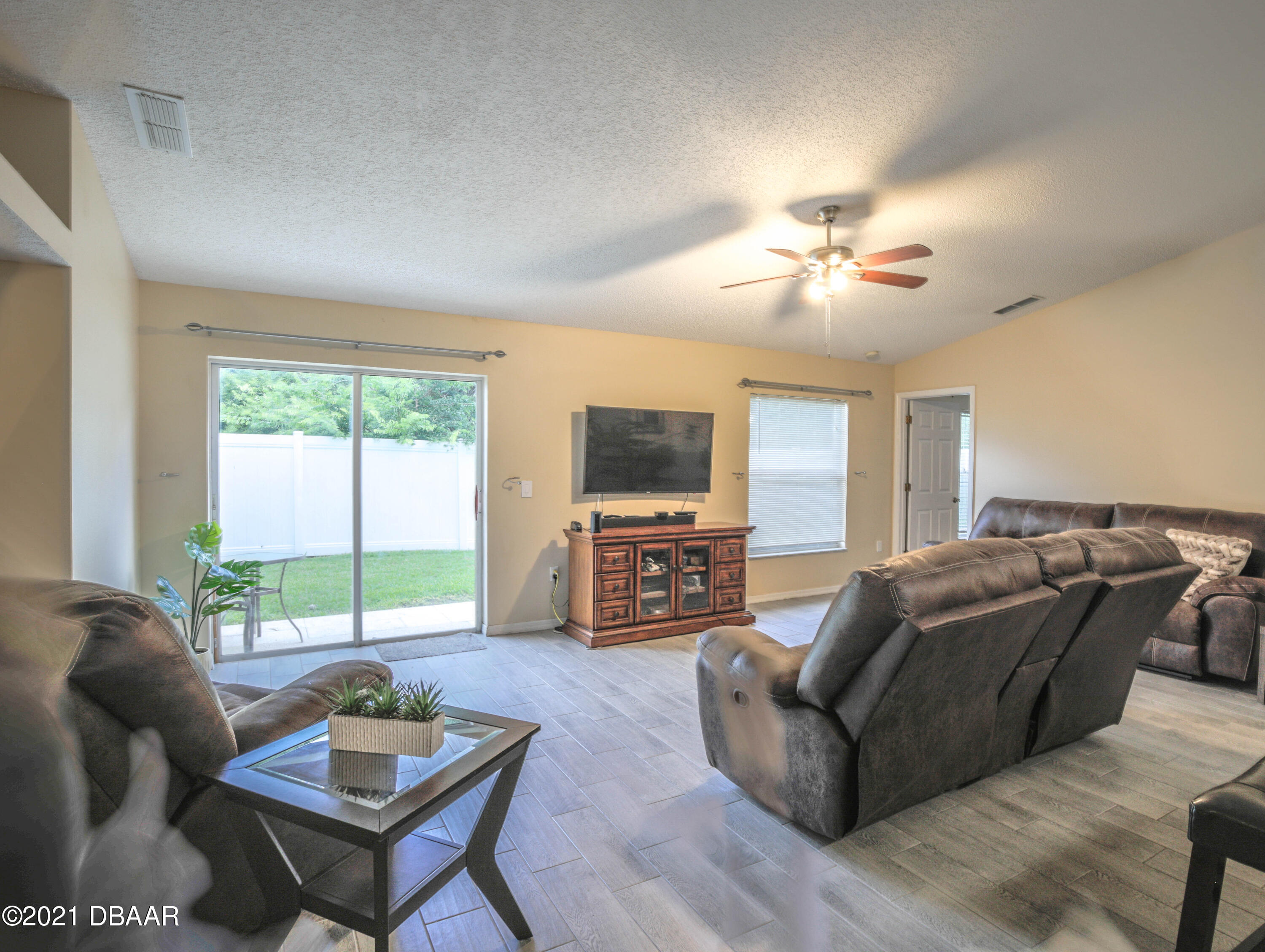 1811 Lime Tree Drive Edgewater, FL 32132 - Photo 11 of 35 a living room with furniture a flat screen tv and a large window