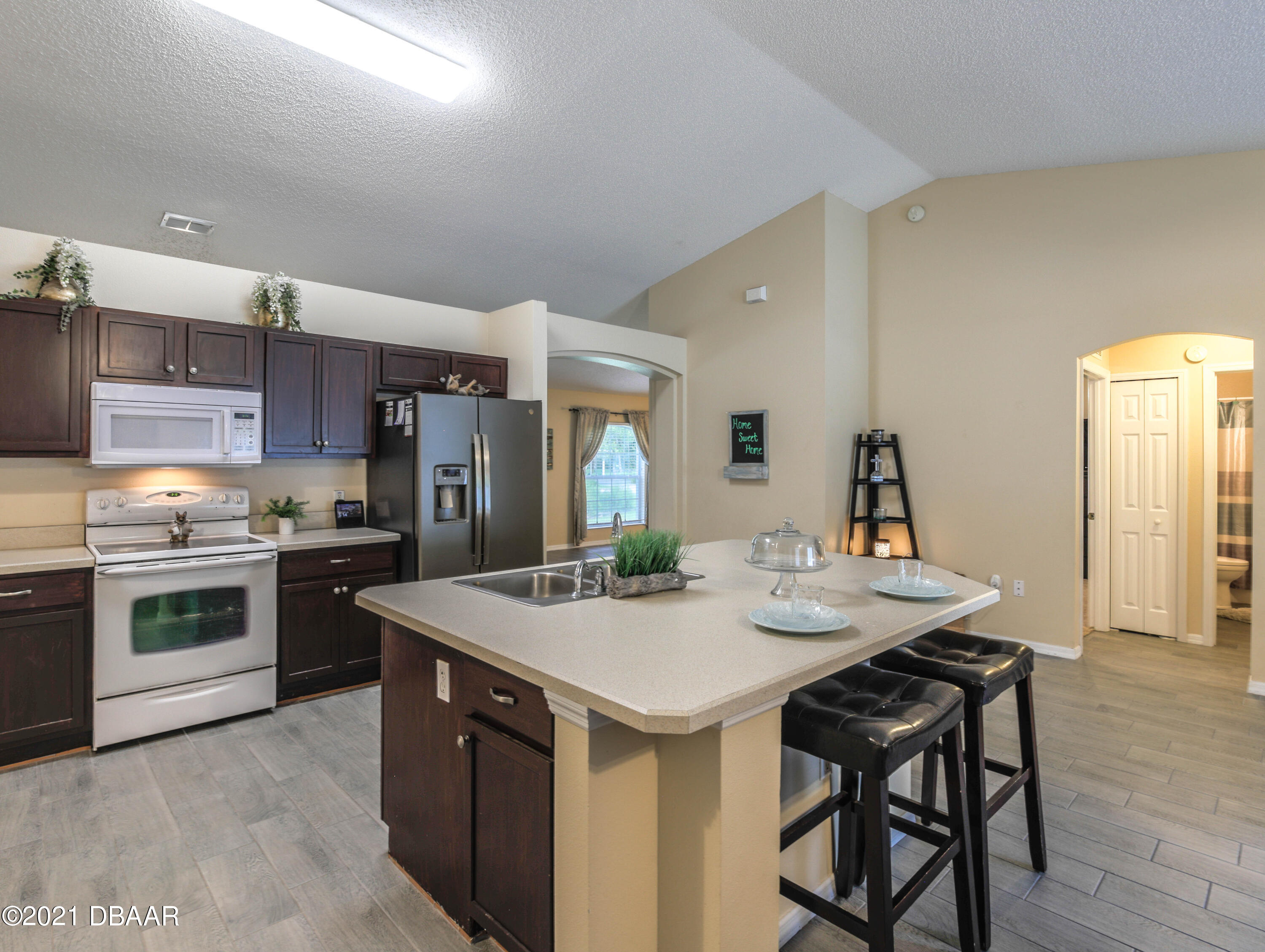 1811 Lime Tree Drive Edgewater, FL 32132 - Photo 15 of 35 a kitchen with a stove a sink and a refrigerator