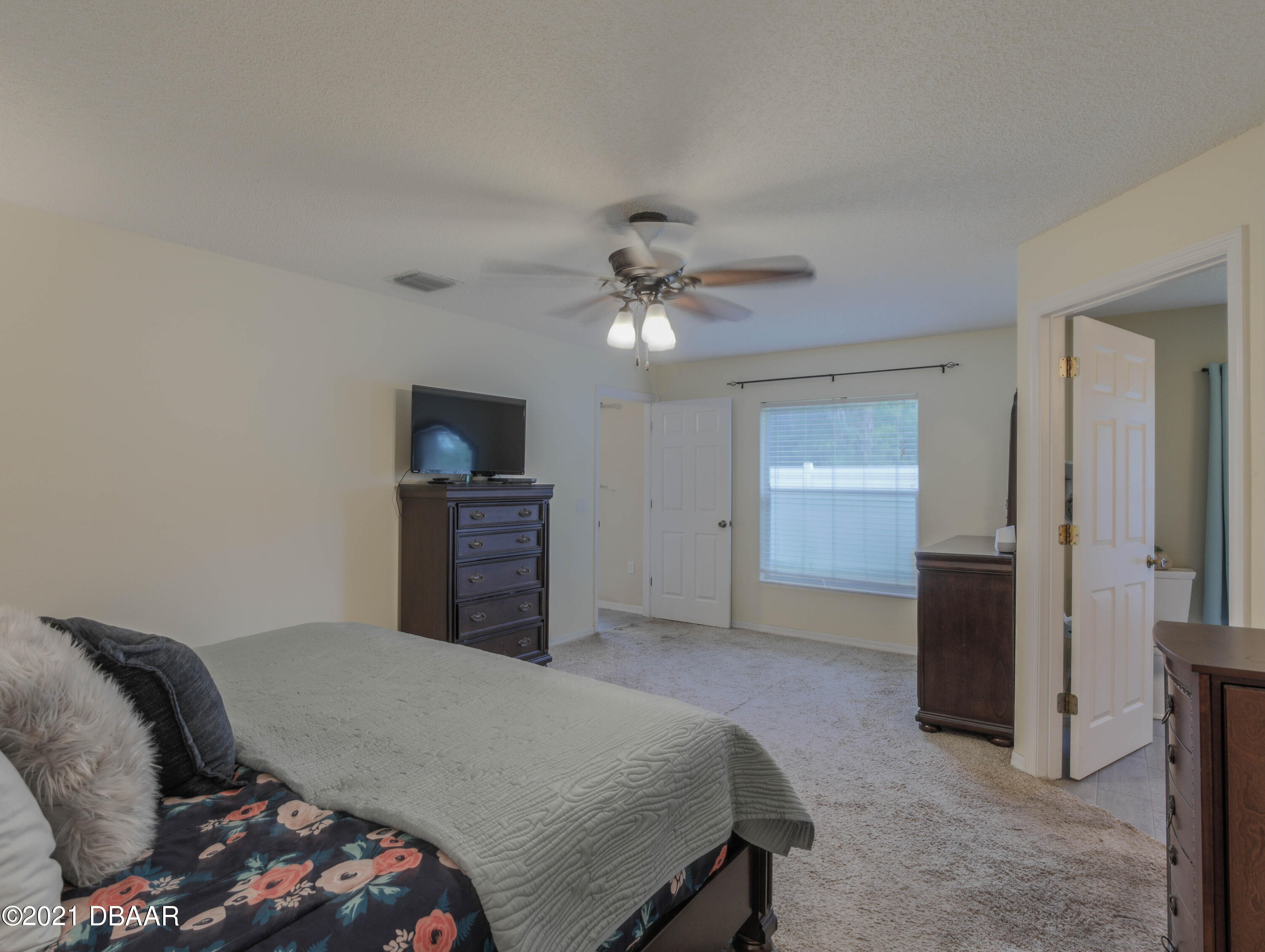 1811 Lime Tree Drive Edgewater, FL 32132 - Photo 17 of 35 a bedroom with a bed and a ceiling fan