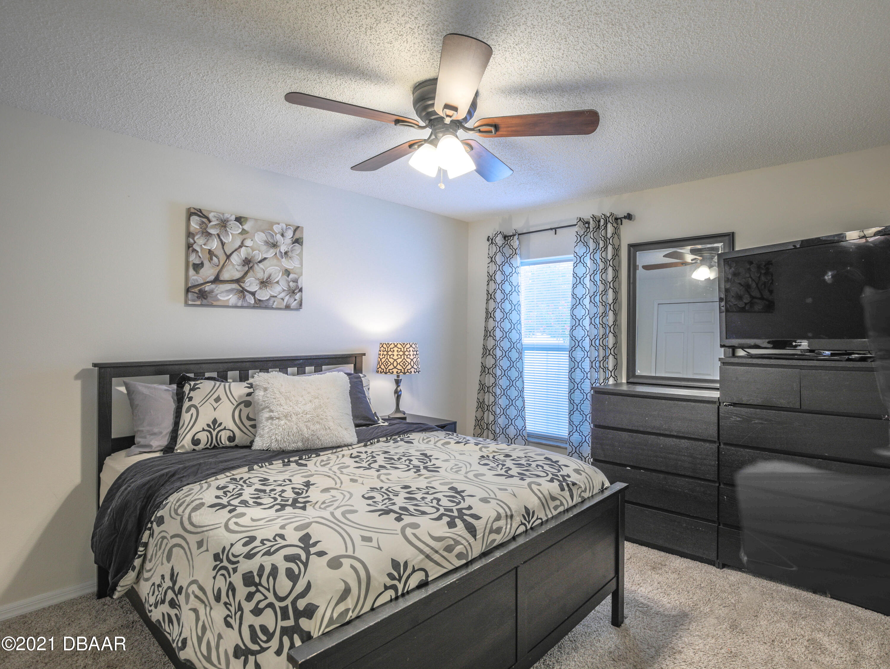 1811 Lime Tree Drive Edgewater, FL 32132 - Photo 20 of 35 a bedroom with a bed and a chandelier