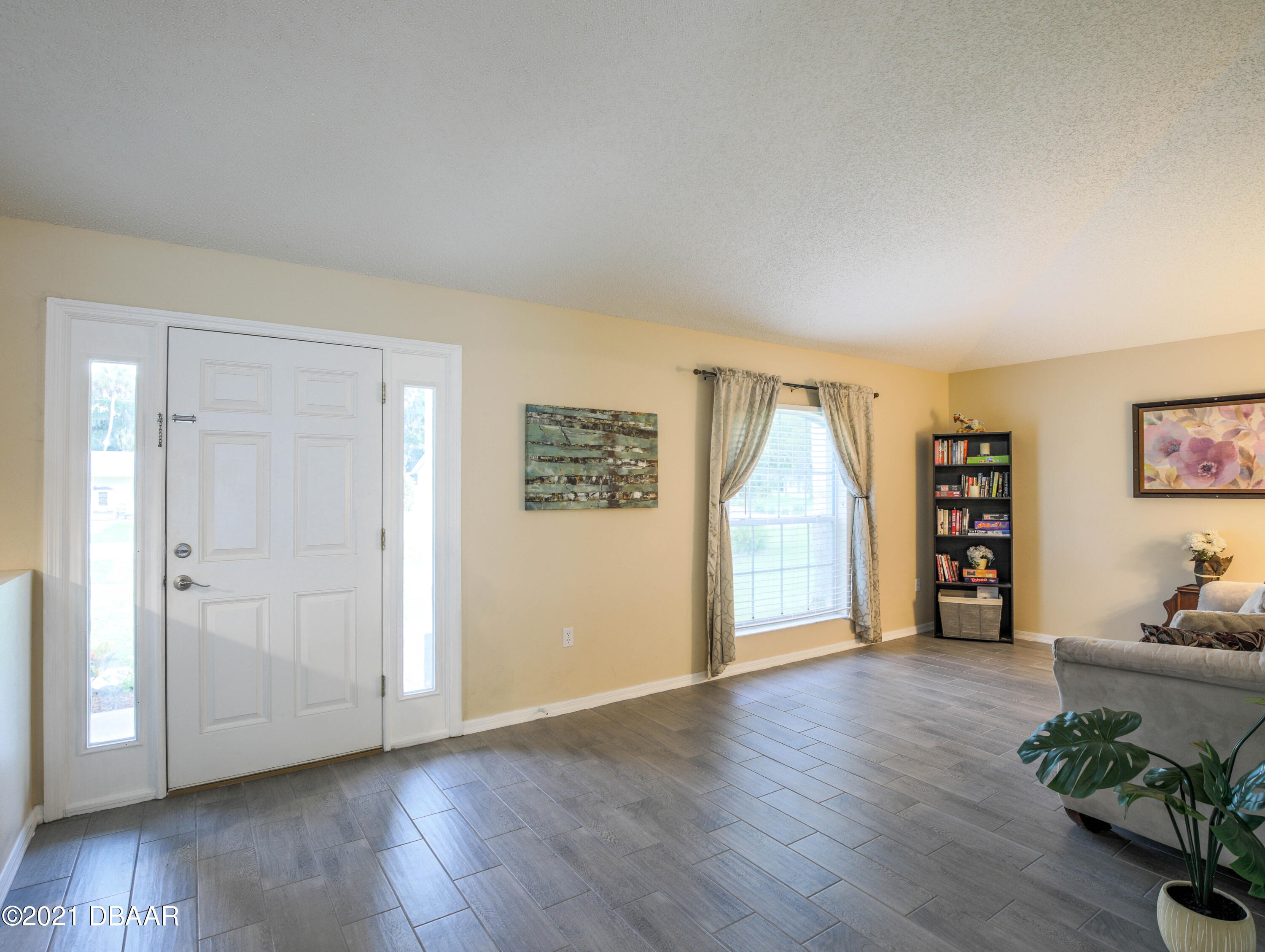 1811 Lime Tree Drive Edgewater, FL 32132 - Photo 7 of 35 a view of an empty room with wooden floor and a window