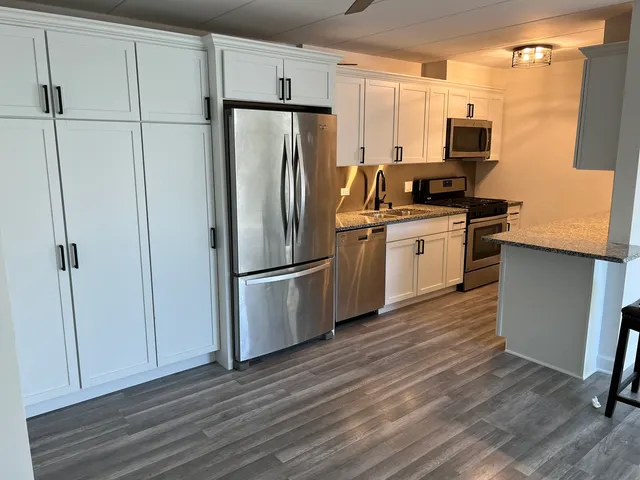 a kitchen with stainless steel appliances a refrigerator sink and microwave