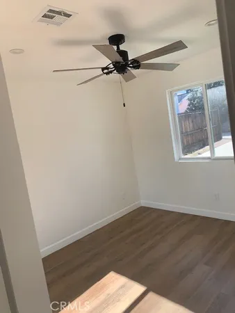 a view of a small space with wooden floor and a window