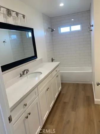 a bathroom with a sink a large mirror and a bathtub