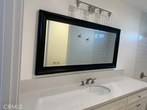 a bathroom with a sink vanity and a mirror