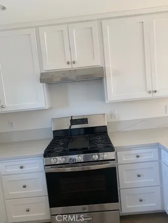 a stove top oven sitting inside of a kitchen