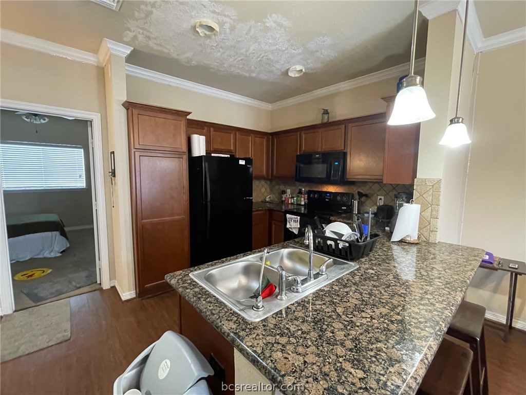 1198 Jones-Butler Road, Unit 2706 College Station, TX 77840 - Photo 4 of 17 a kitchen with stainless steel appliances granite countertop a refrigerator a stove and a sink