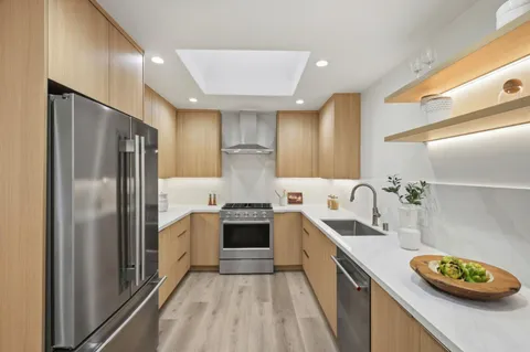 a kitchen with stainless steel appliances granite countertop a sink stove and refrigerator