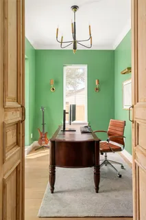 a dining room with furniture potted plants and wooden floor