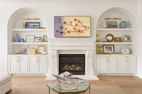 a living room with white cabinets and a fireplace