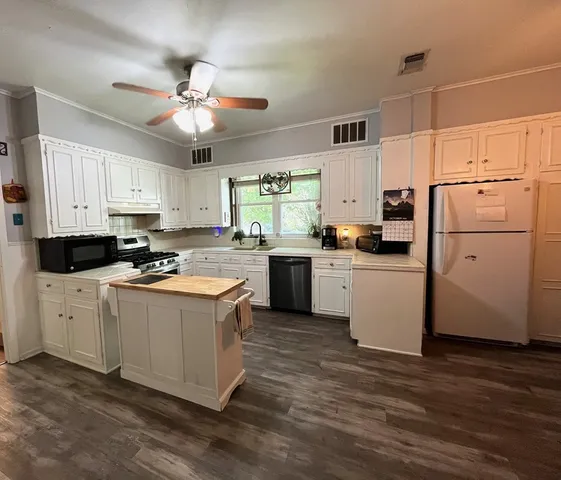 a kitchen with white cabinets and white appliances