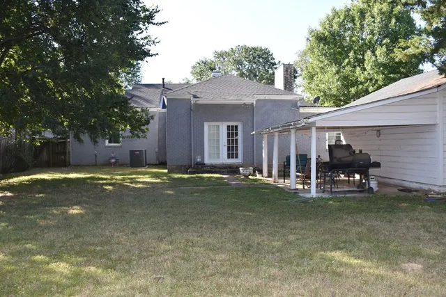 a view of a house with backyard and a tree