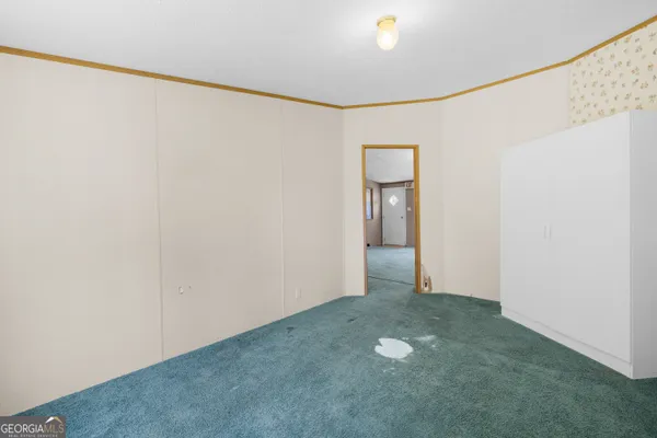 a view of a big room with windows and chandelier fan