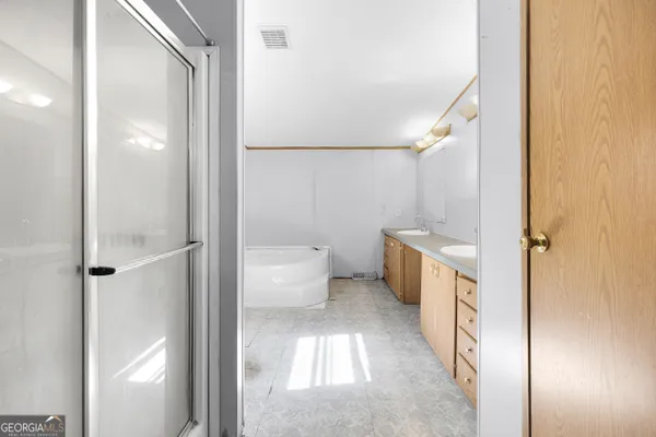 a bathroom with a tub sink and mirror