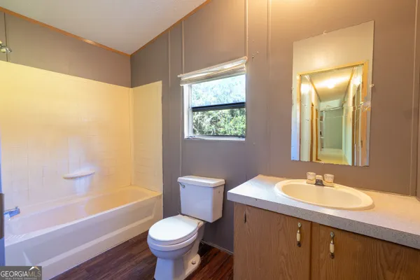 a view of a house with a small yard and wooden floor and fence