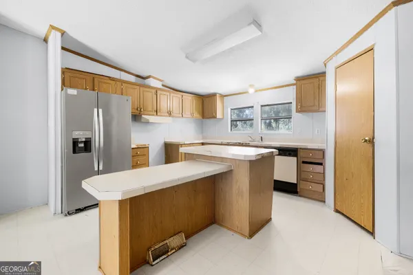 a kitchen with a sink refrigerator and cabinets